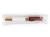 un stylo plume rouge et doré posé sur un sac transparent
