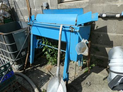 une machine bleue posée par terre près d'un mur