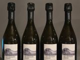 quatre bouteilles de vin sont alignées sur une table