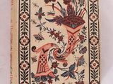 un vieux livre sur lequel figure l'image d'un oiseau et de fleurs