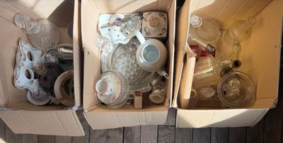 deux boîtes contenant divers objets, posées sur un plancher en bois