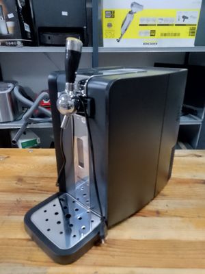 a beer dispenser sitting on a table in a kitchen