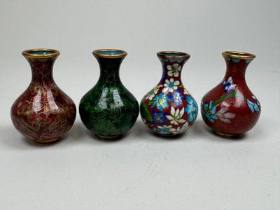 trois vases aux motifs différents sont alignés sur une surface blanche
