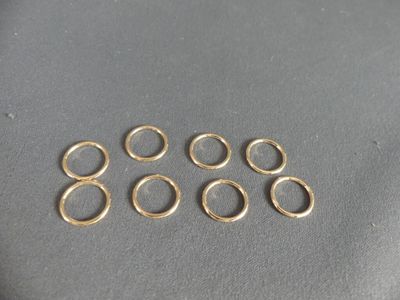 a close up of a bunch of gold rings on a table