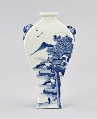 un vase bleu et blanc orné d'un paysage de montagne