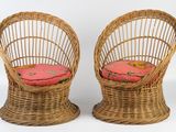 une paire de chaises en osier avec des coussins roses sur fond blanc
