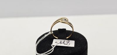 un gros plan d'une bague exposée dans une vitrine, accompagnée d'une étiquette portant un nom