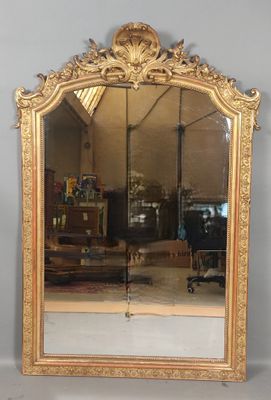 a large mirror with a gold frame on the wall