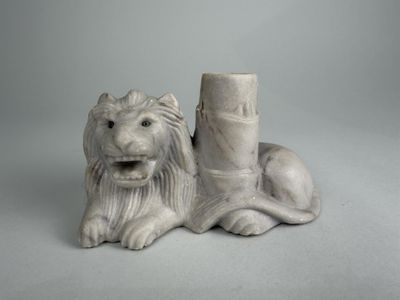 a statue of a lion that is sitting next to a pillar