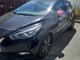 the black car is parked in front of a shipping container