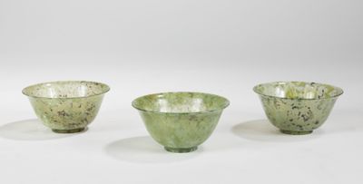 trois bols en verre vert posés l'un à côté de l'autre sur une surface blanche
