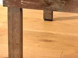 a wooden table with a tile top on a hard wood floor