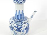 un vase bleu et blanc muni d'une anse, sur un fond blanc