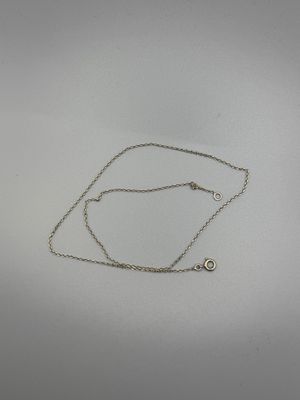 un gros plan d'un collier en argent orné d'un diamant