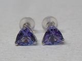 paire de boucles d'oreilles en tanzanite taille « trillion » sur un fond blanc