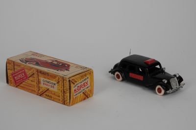 une petite voiture miniature noire à côté d'un paquet de cigarettes
