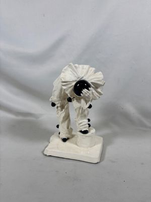une figurine représentant un homme en costume blanc