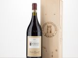 the bottle of red wine is next to a wooden box