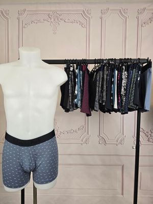 un mannequin masculin devant un présentoir de vêtements