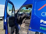 a blue van with the door open on a dirt road