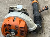 an orange and black blower sitting on the ground next to a blower