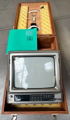 un petit téléviseur posé sur une caisse en bois