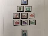 german postage stamps displayed on a white wall in a museum