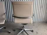 two office chairs sitting next to each other in front of a corrugated wall