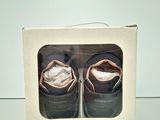 two pairs of baby shoes in a box on a table