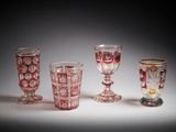 several glass goblets are lined up in a row on a white surface