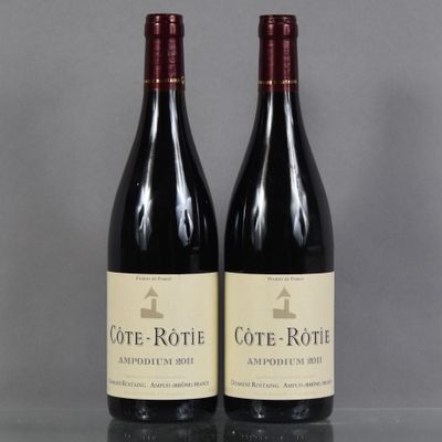 two bottles of wine sitting on top of a table next to each other