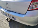 the rear end of a silver car with a license plate on it ' s bumper