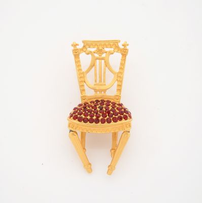 a miniature chair made out of wood with a red seat