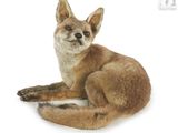 un renard en peluche allongé sur une surface blanche