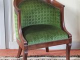 une chaise verte placée dans une pièce où il y a un tapis au sol