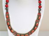 une photo d'un collier avec des perles rouges porté par un mannequin