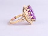 a close up of a gold ring with a purple stone in it