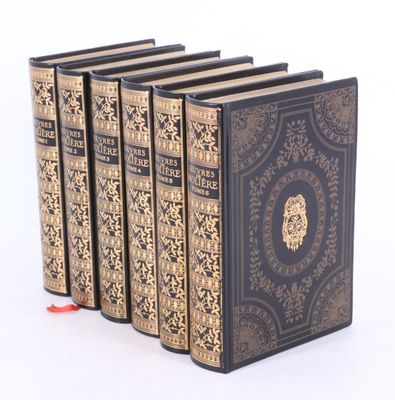 cinq livres sont empilés les uns sur les autres sur une surface blanche