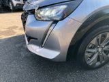 the front end of a silver car with a denting dent on it