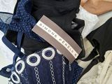 many different types of bags and purses on a bed