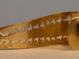 brass plated cuff with cut out design on top of a table