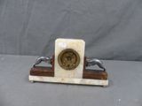 a marble clock on a stand with two birds on it