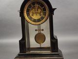 une horloge posée sur une table à côté d'une paire de ciseaux