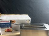 a toaster that is sitting on a table next to a box