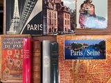 plusieurs livres posés sur une table sur laquelle se trouve une carte de Paris