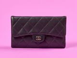 un sac à main Chanel noir sur fond rose