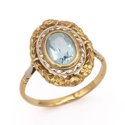 a close up of a gold ring with a blue topaz stone