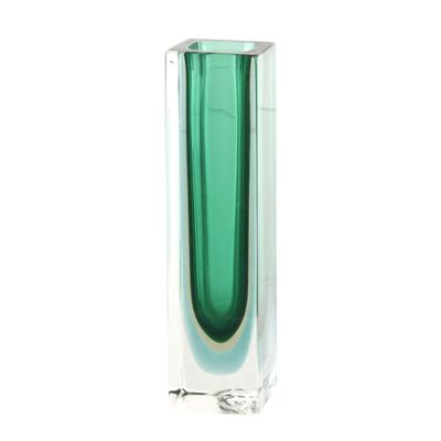 un vase vert posé sur une surface blanche