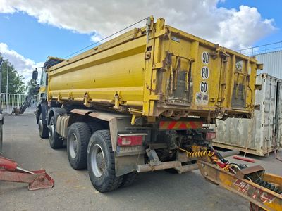 un camion-benne jaune garé sur un parking