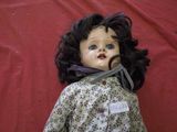 a close up of a doll on a red surface